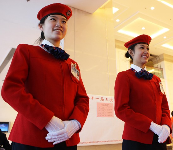 图文:两名服务员迎候全国政协委员入驻